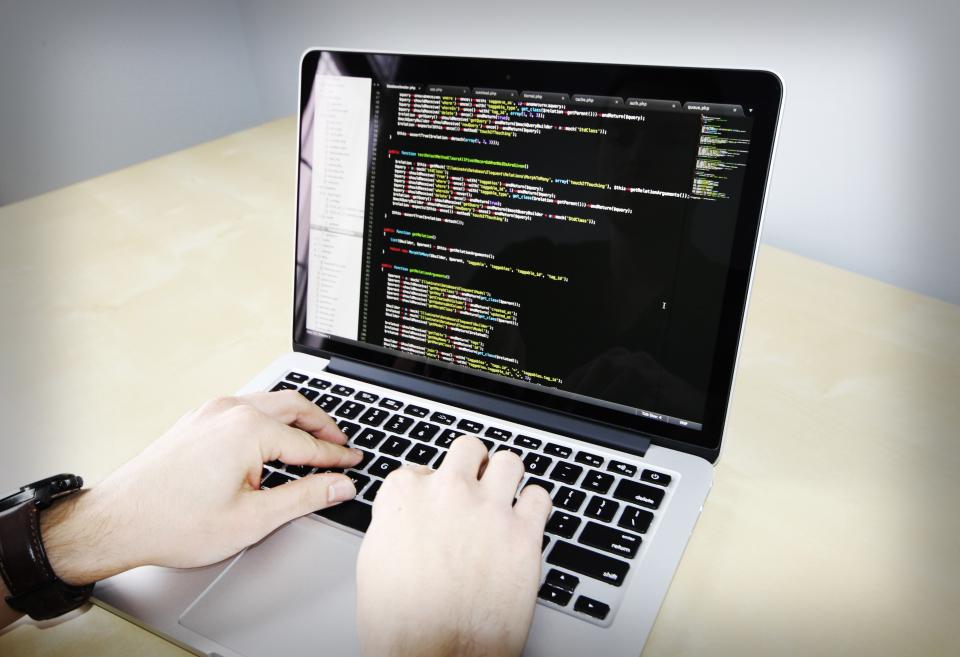 Gestor comparando opções de software em tela de computador no escritório